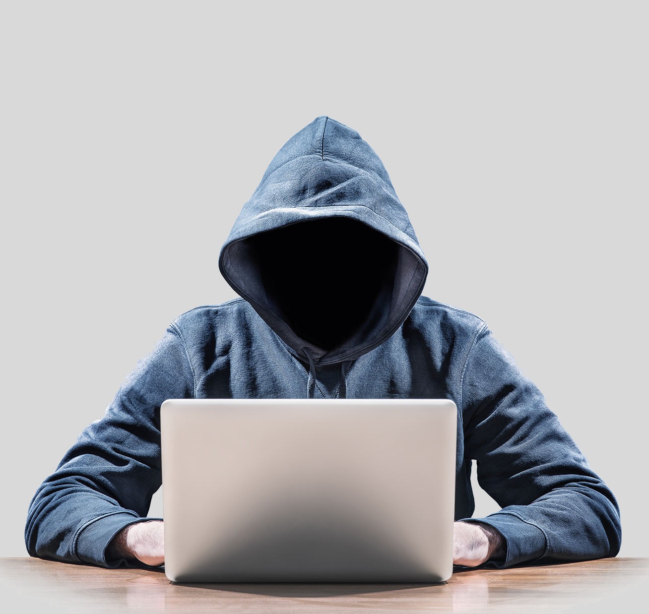 Persoon met kapuchon op achter een laptop Persoon met kapuchon op achter een laptop